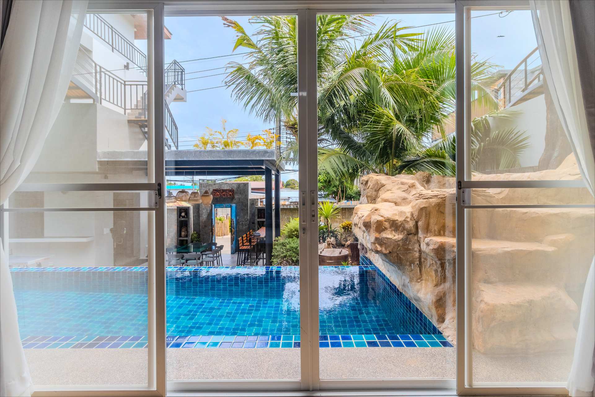 Poolside lounge area with sun beds and tropical surroundings for group relaxation