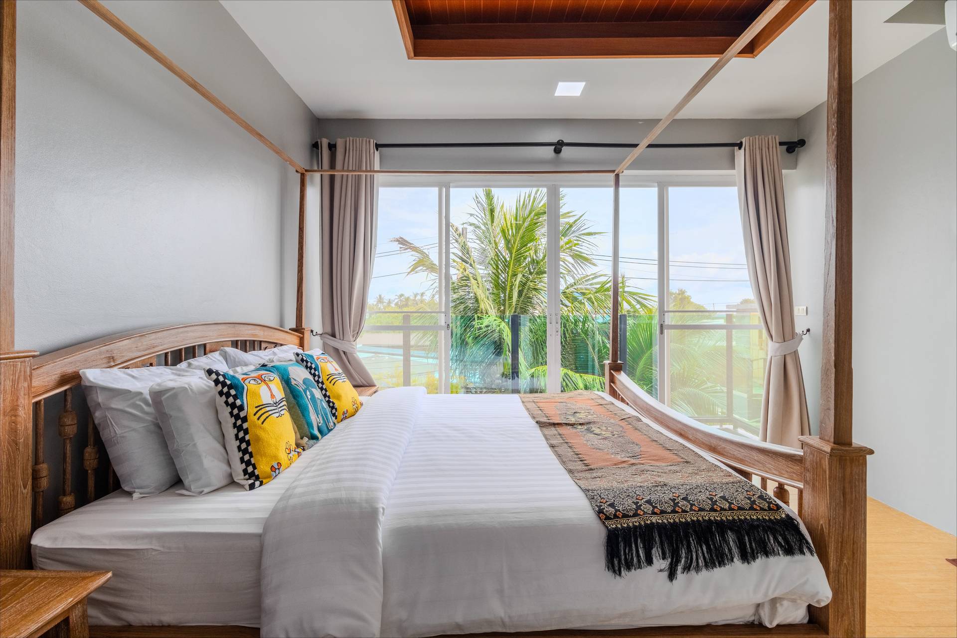 Bright bedroom with garden views and art cushions