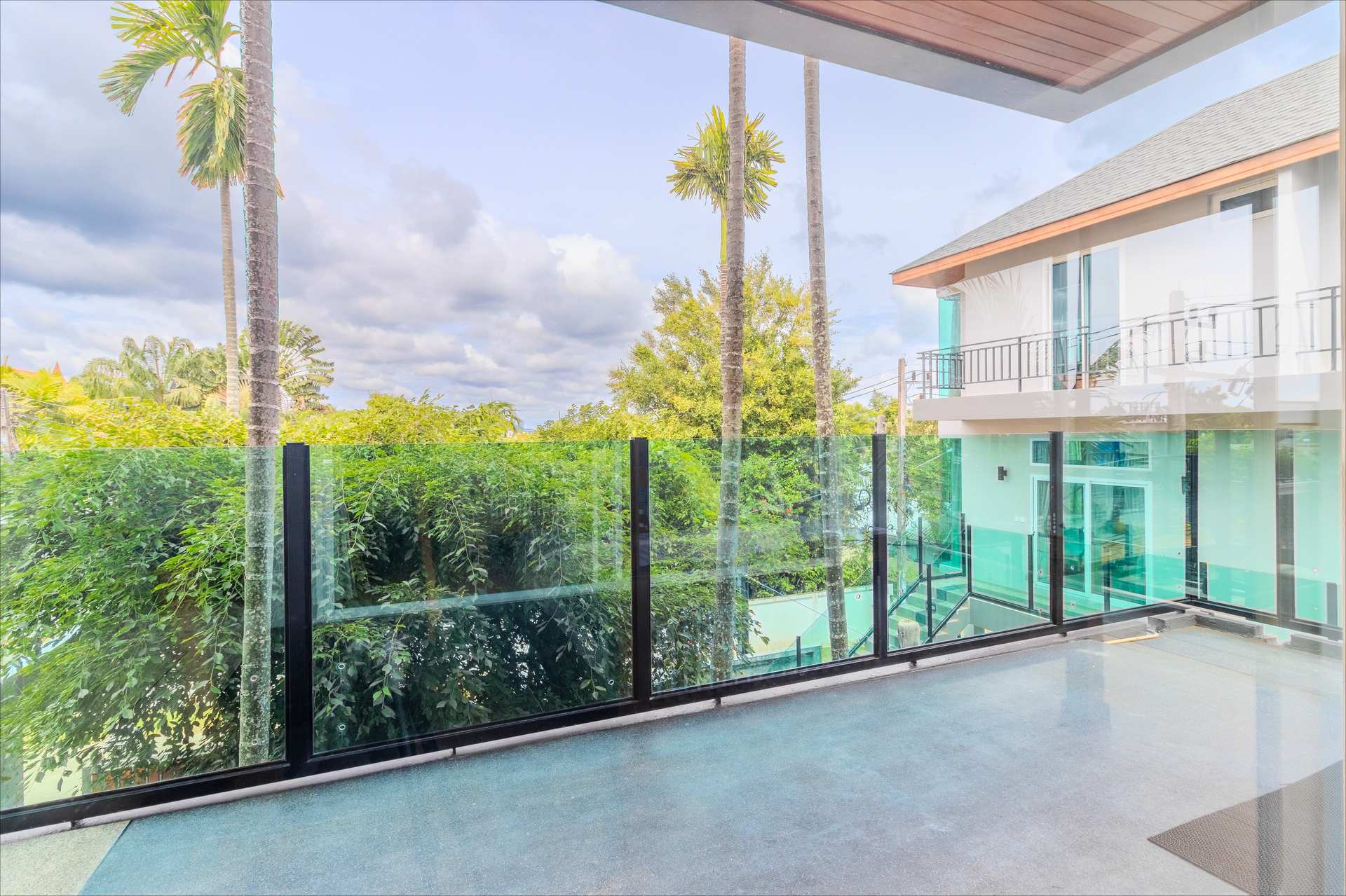 Glass-railed terrace overlooking pool and gardens