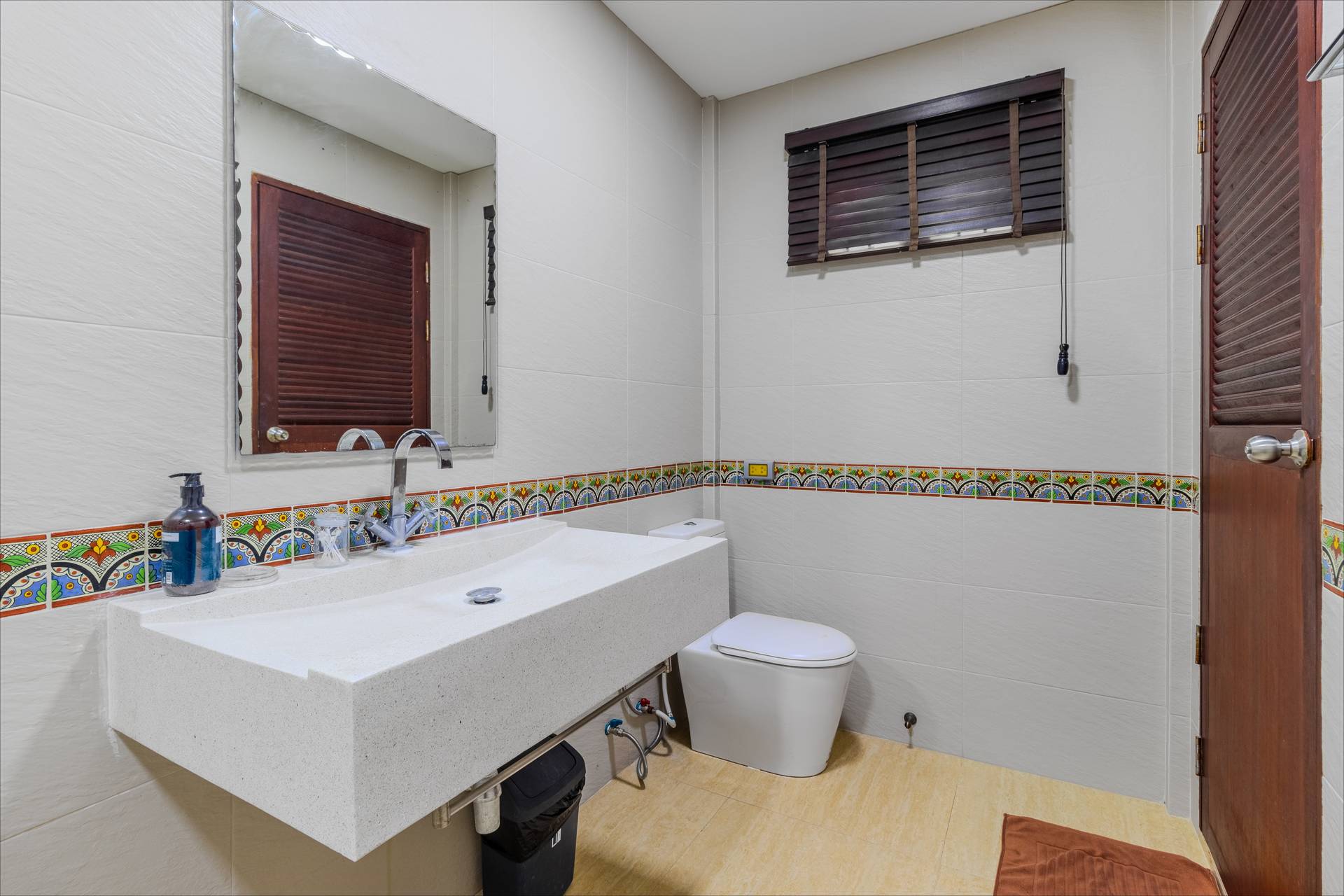 En-suite bathroom with stone vanity and shutters