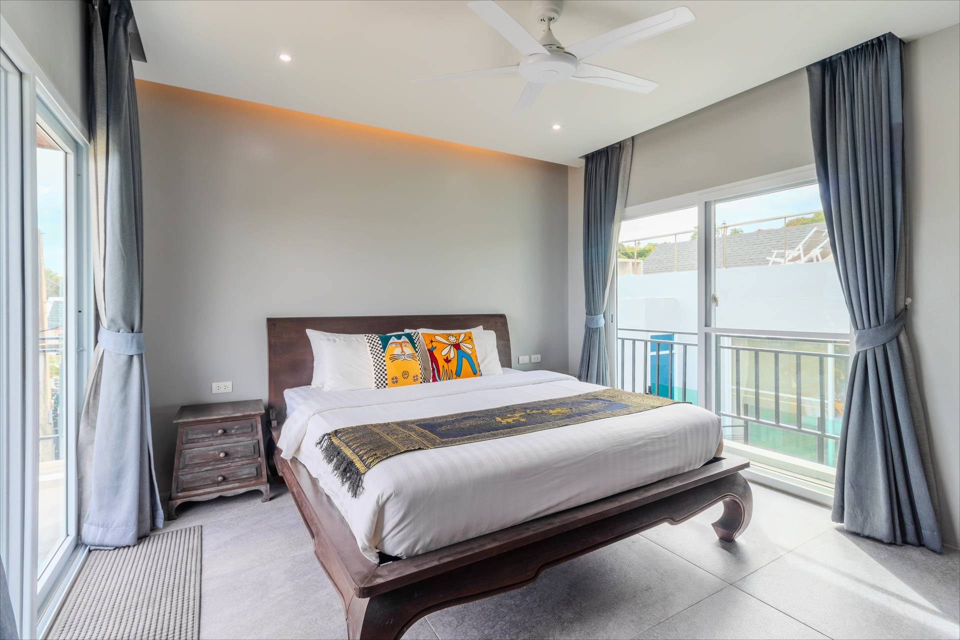 Spacious bedroom with private balcony and garden views in the Phuket villa