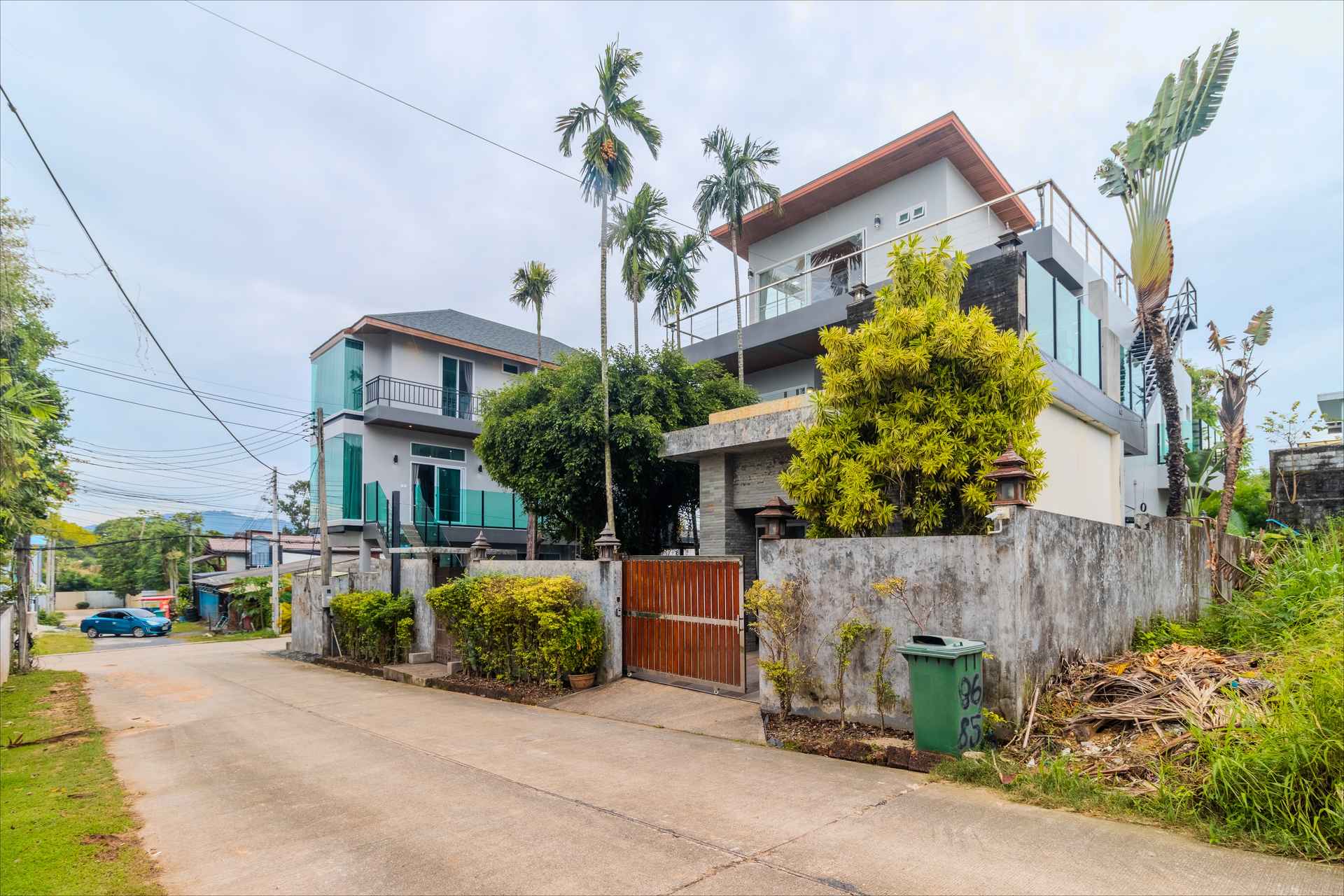 Front facade with tropical landscaping and gated entrance