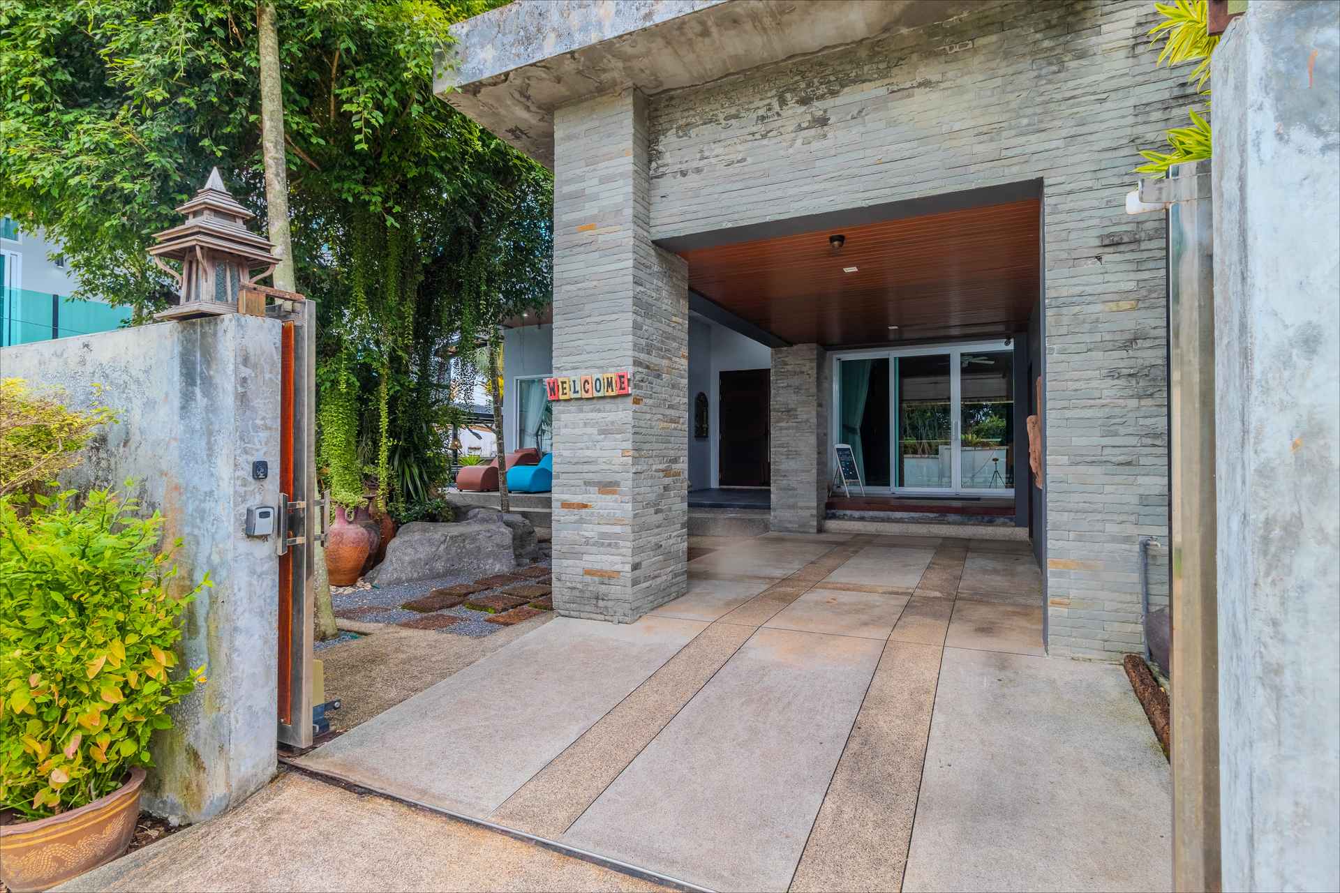 Stone-clad entrance portico with covered carport