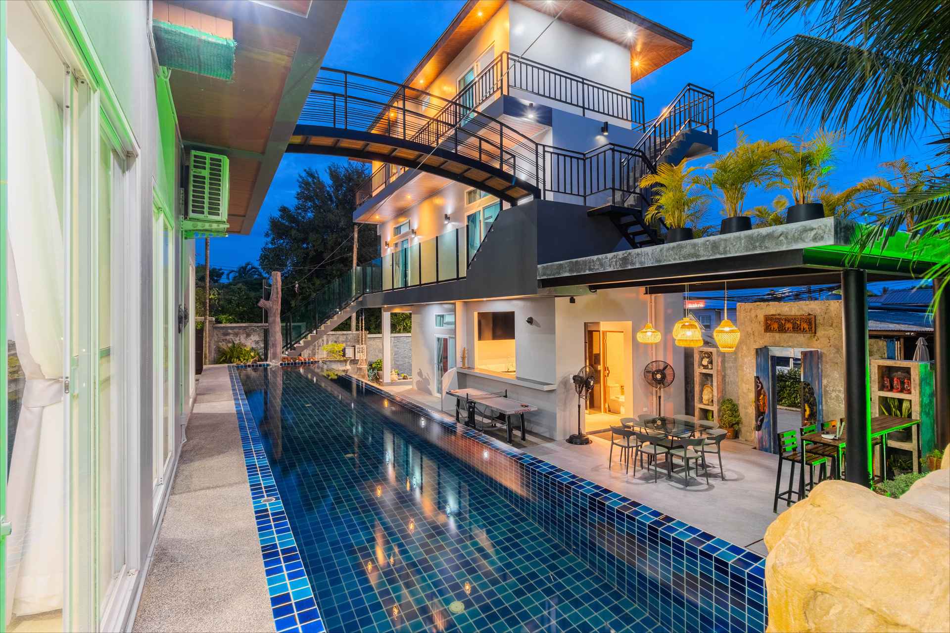 Luxury 10-bedroom group villa in Rawai Phuket with illuminated pool and entertainment area at dusk